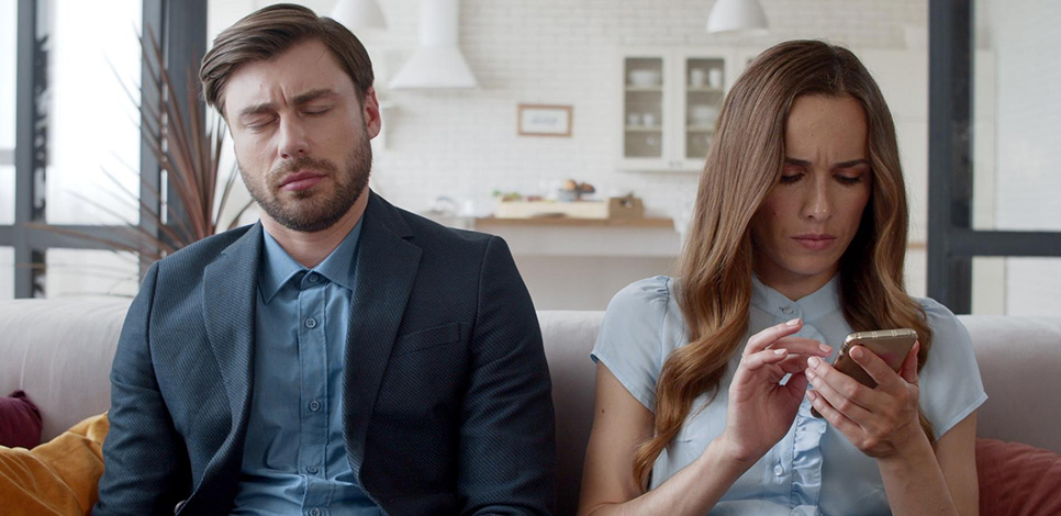 Mann wirkt unzufrieden, Frau schaut aufs Handy – Symbol für die begrenzte Dauer von Rebounds