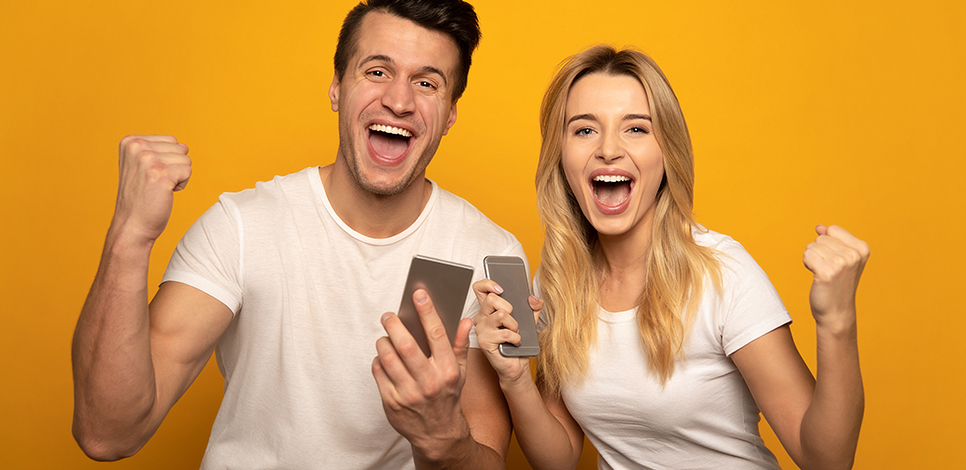 Fröhliches Paar jubelt mit Smartphone – was nach dem Anschreiben der Ex nach Kontaktsperre passiert